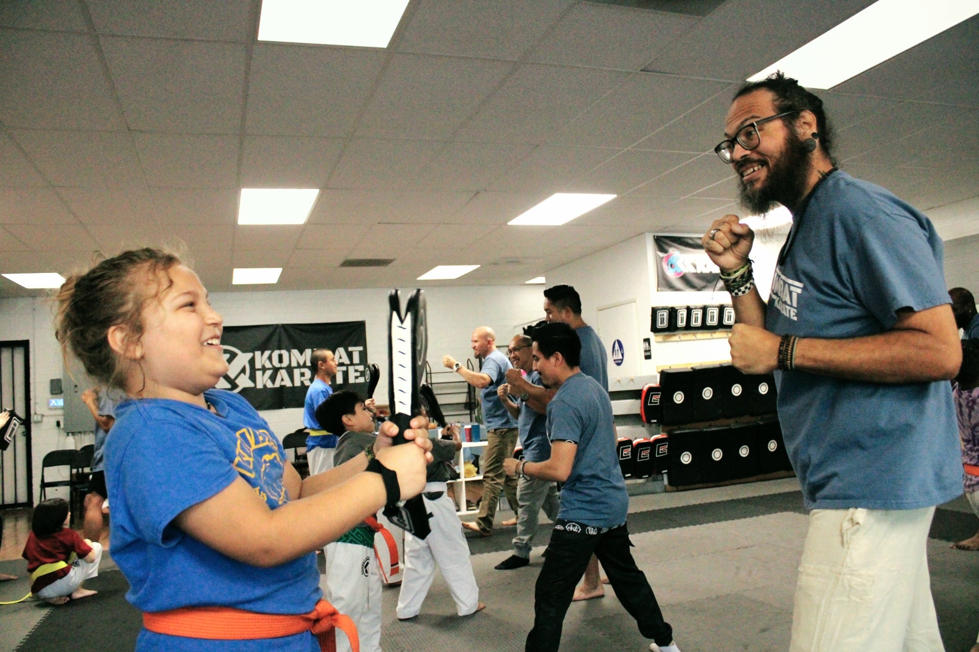 Karate class practicing kicks in unison at our Long Beach dojo
