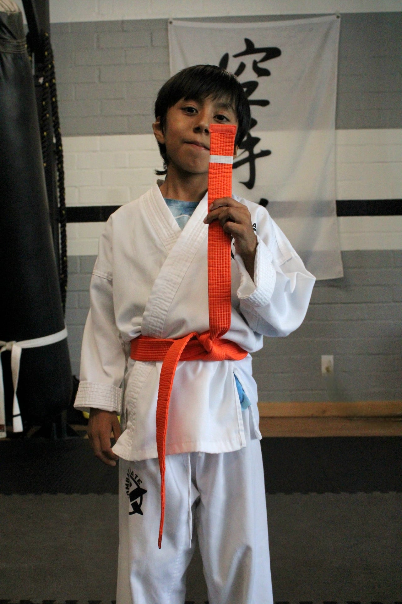 Young student breaking a board during a karate test in Long Beach